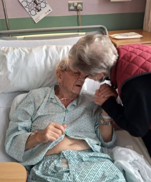 Two elderly individuals; one is a patient, the other is a visitor.